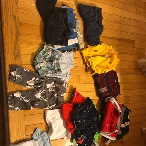 Lot of baby boy clothes and bibs.